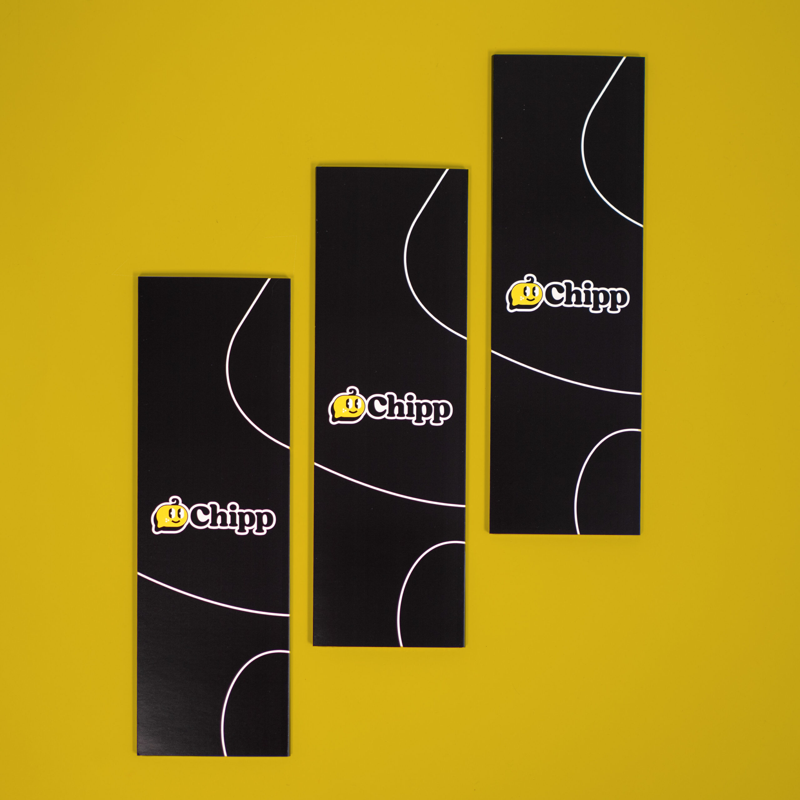 Chipp NCF phone stand wraps laying flat in a diagonal layout on a yellow background