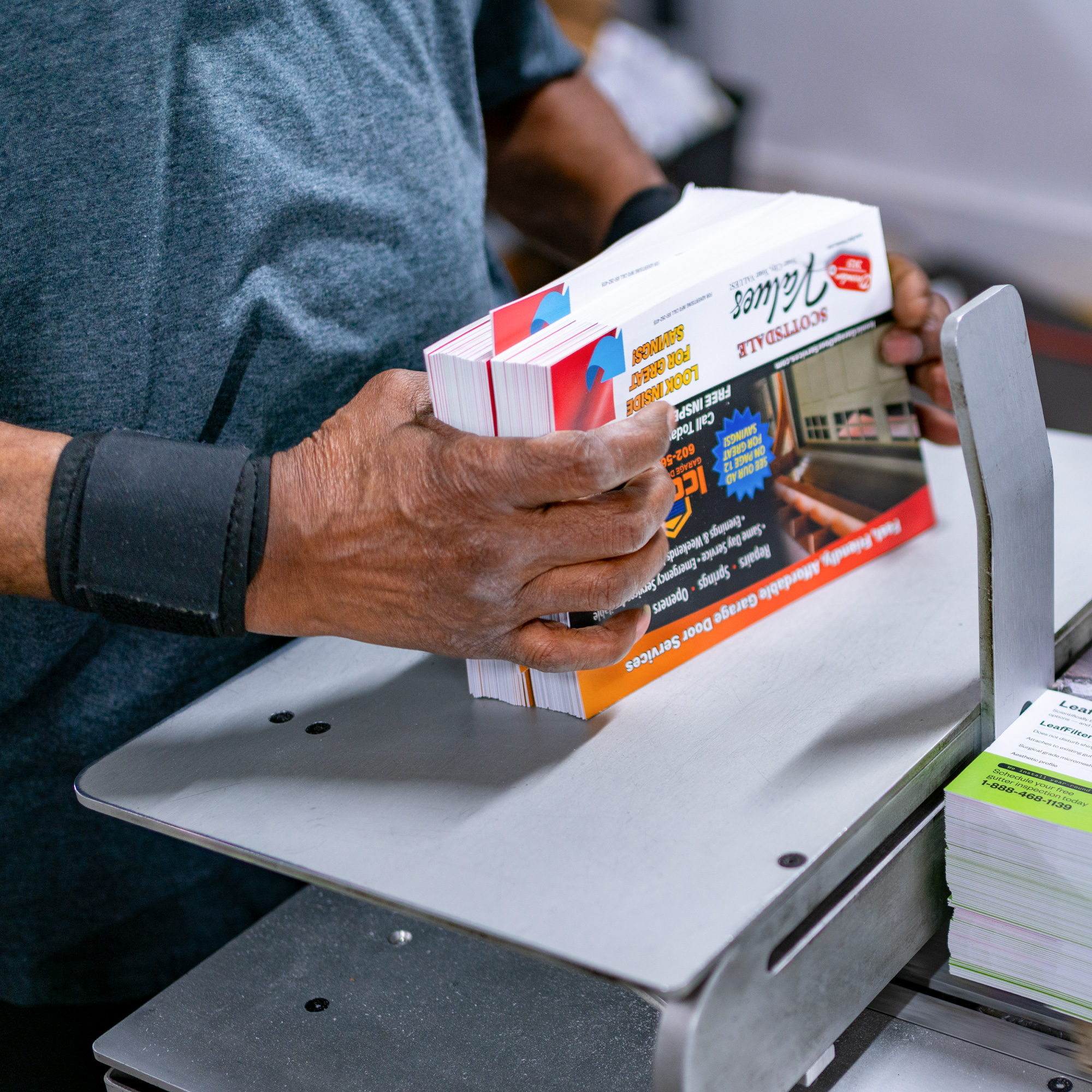 O'Neil employee trimming a stack of direct mail cards