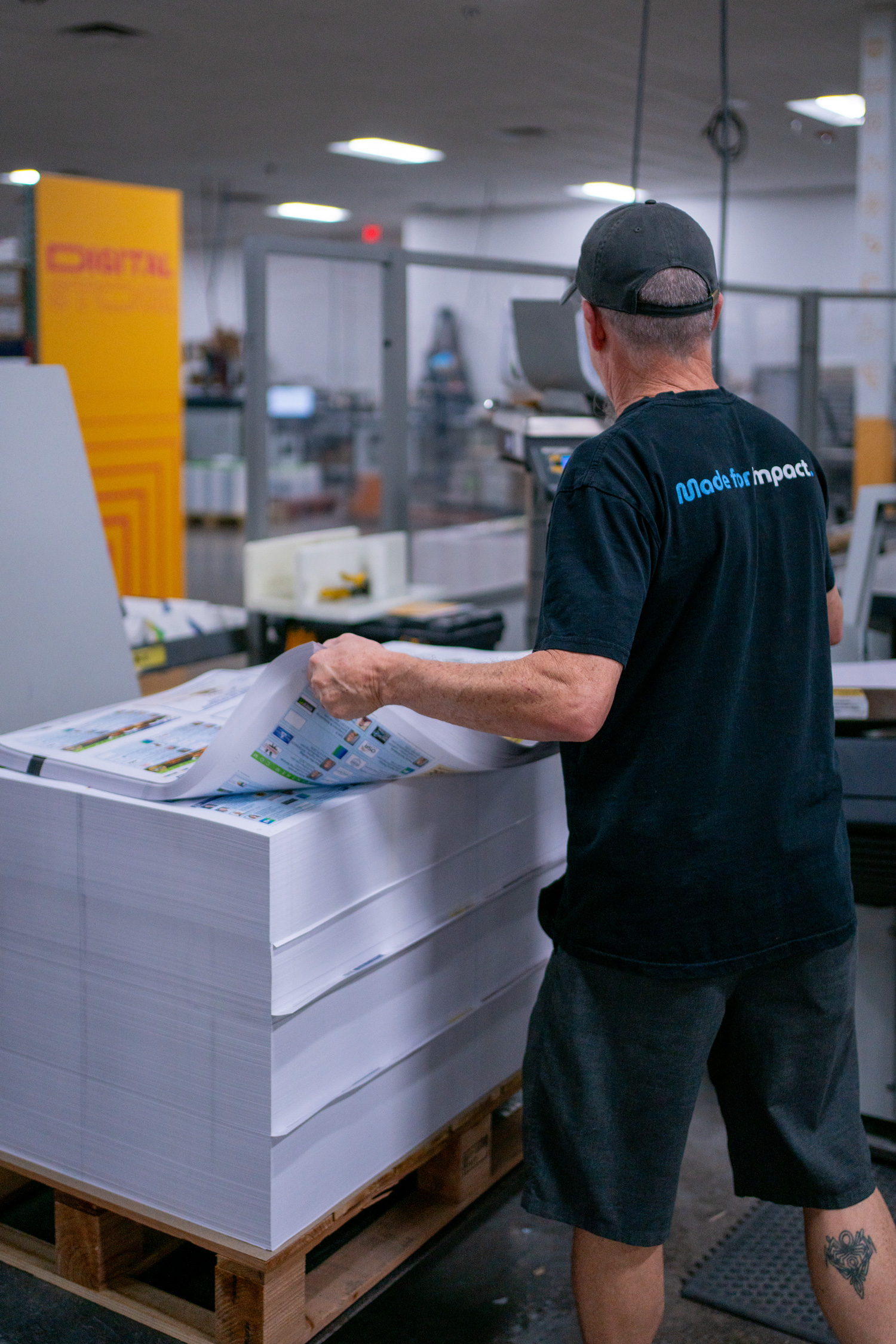 O'Neil employee pulling a sheet off a stack of prints