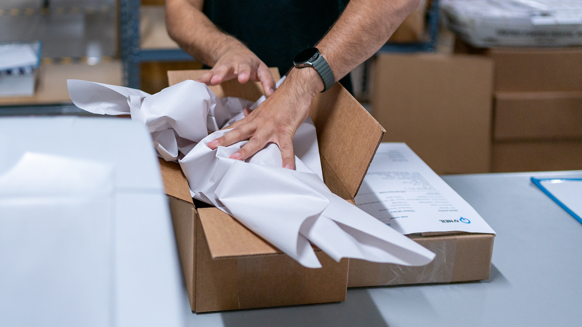 O'Neil team member packing paper into a shipping box