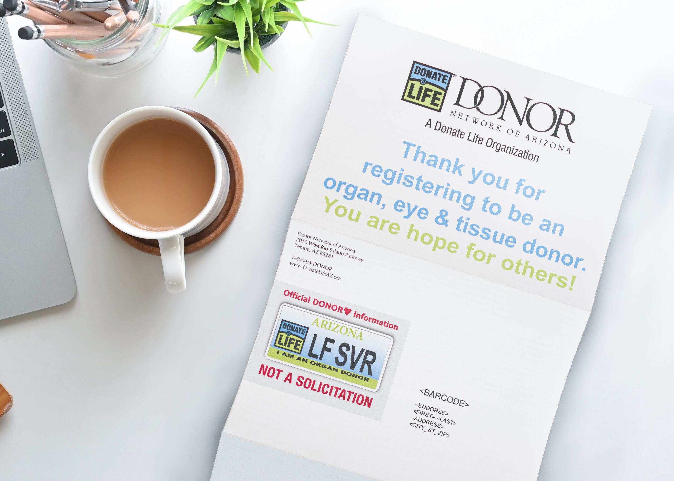 Donor Network unfolded direct mailer on a table next to a cup of coffee