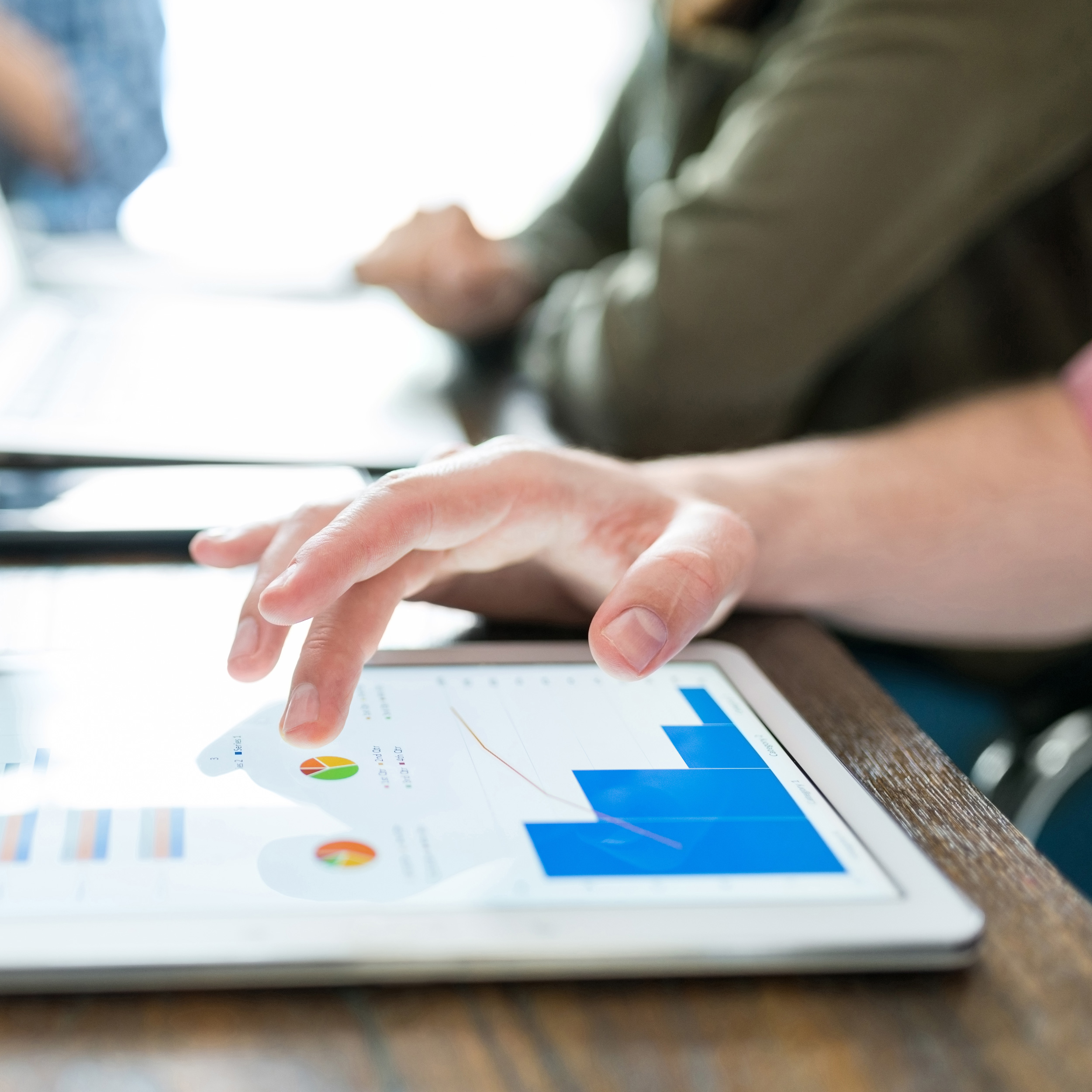 Close up of a professional examining graphs on a tablet