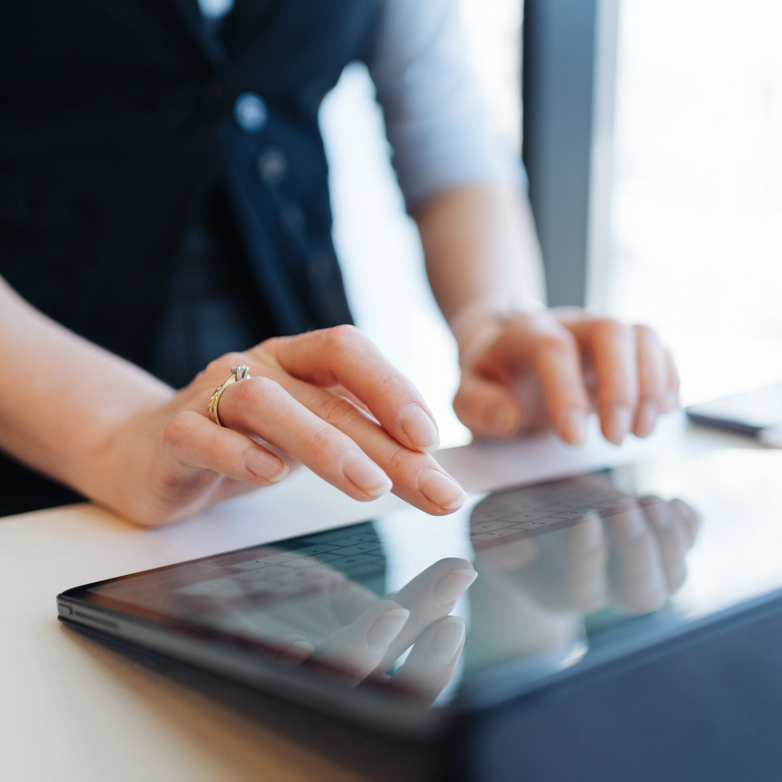Woman fingers typing inscription on digital tablet